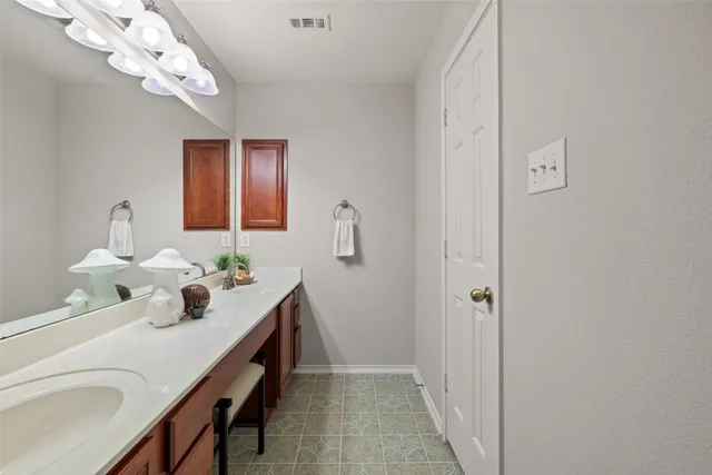 a bathroom with a sink a light fixture and a mirror