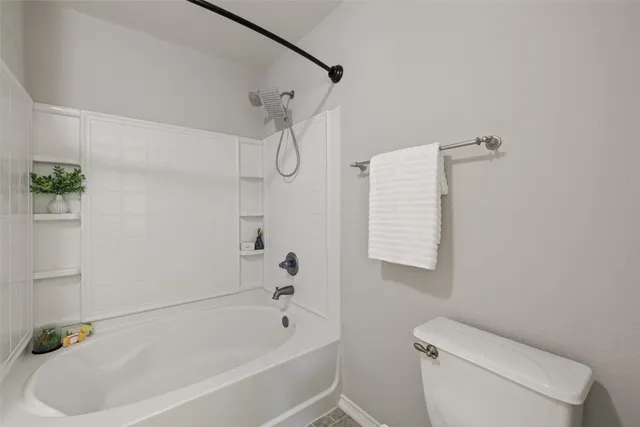 a white bath tub sitting next to a white toilet and sink