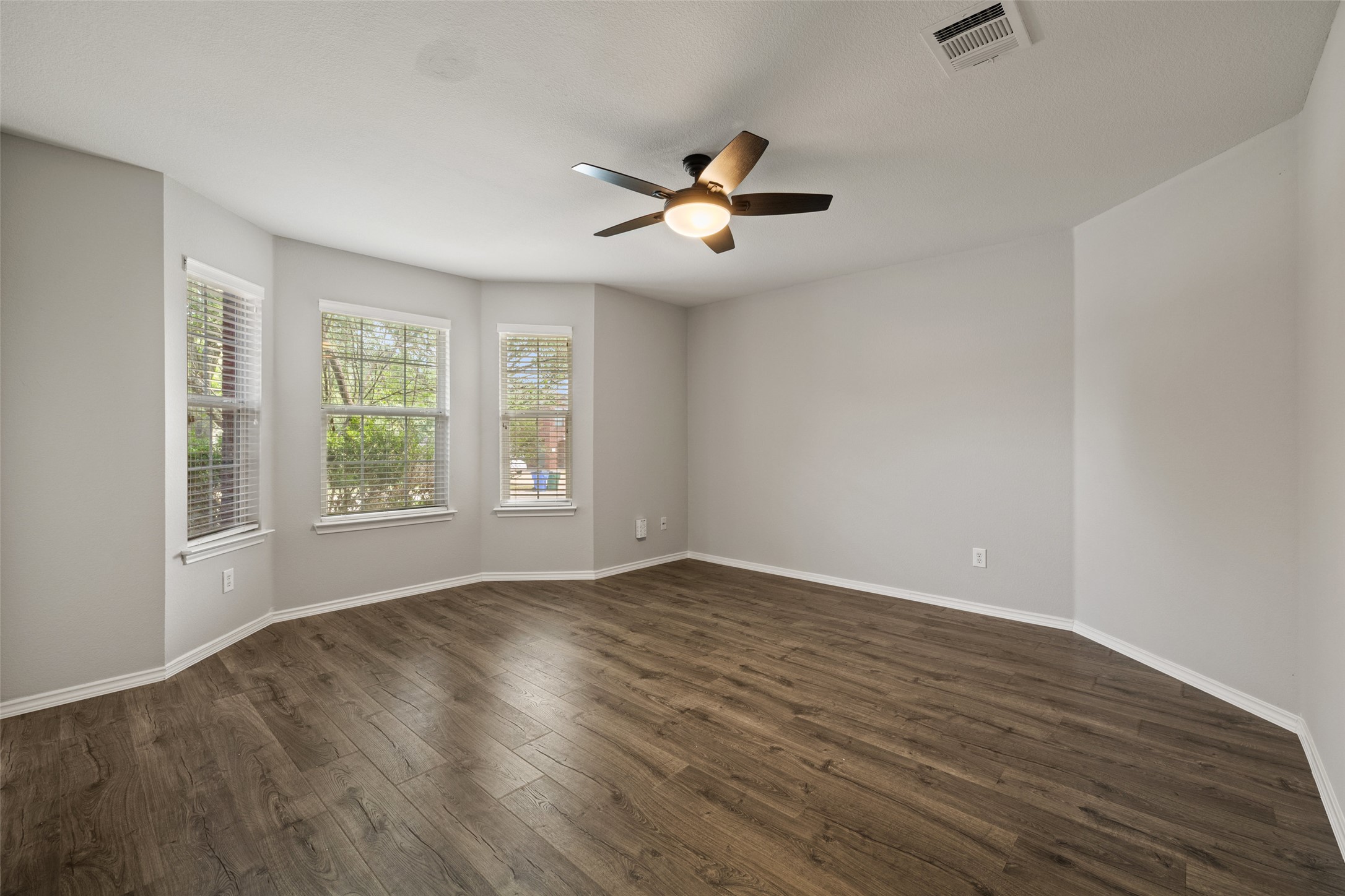 517 Castebar Drive Round Rock, TX 78664 - Photo 23 of 37 Unfurnished room featuring a ceiling fan, dark wood-style floors, and baseboards