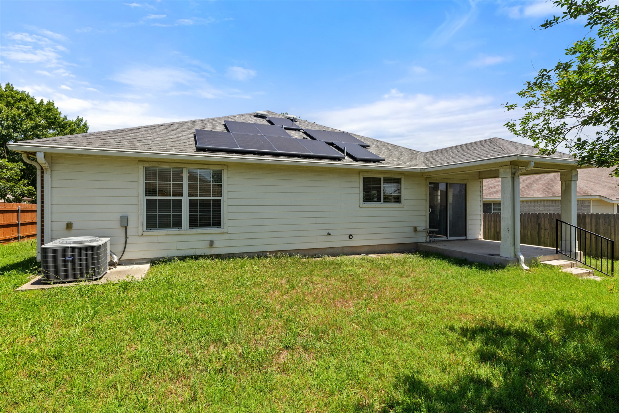 517 Castebar Drive Round Rock, TX 78664 - Photo 30 of 37 Back of house with cooling unit, solar panels, a patio area, and roof with shingles