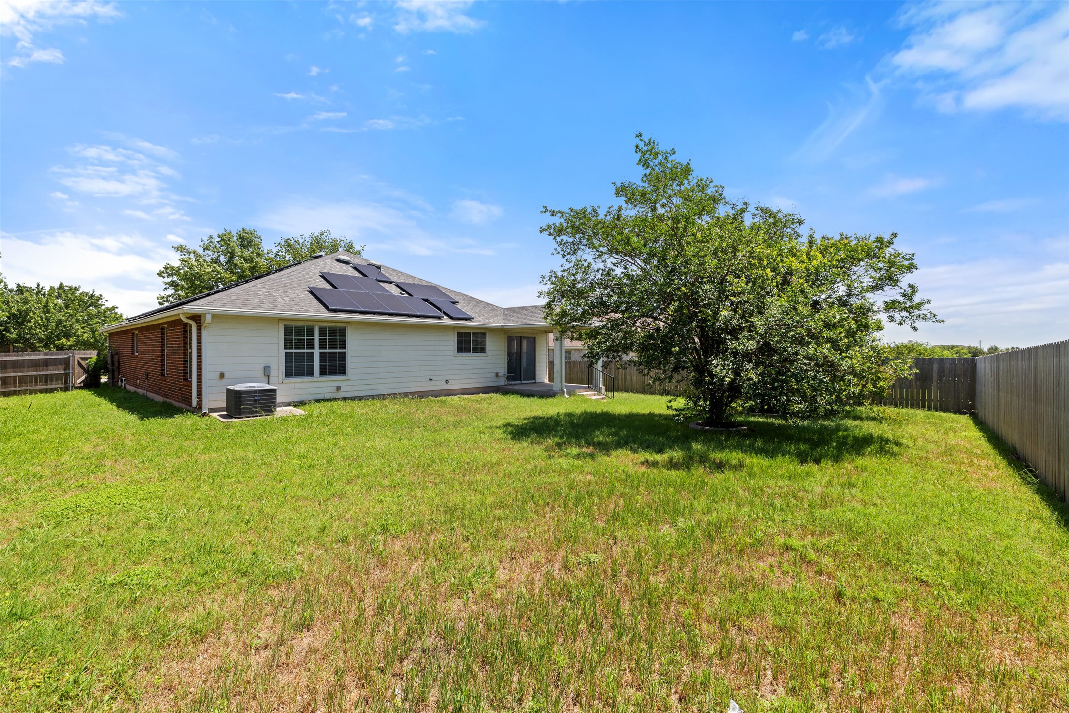 517 Castebar Drive Round Rock, TX 78664 - Photo 31 of 37 Rear view of property with solar panels and central AC