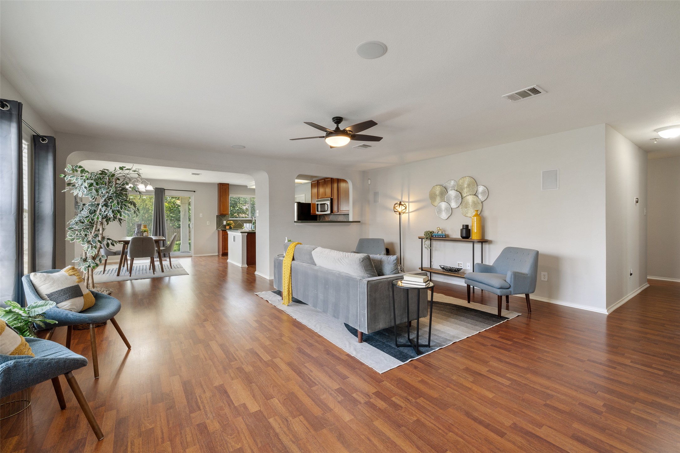 517 Castebar Drive Round Rock, TX 78664 - Photo 9 of 37 Living area featuring wood finished floors, a ceiling fan, arched walkways, and baseboards