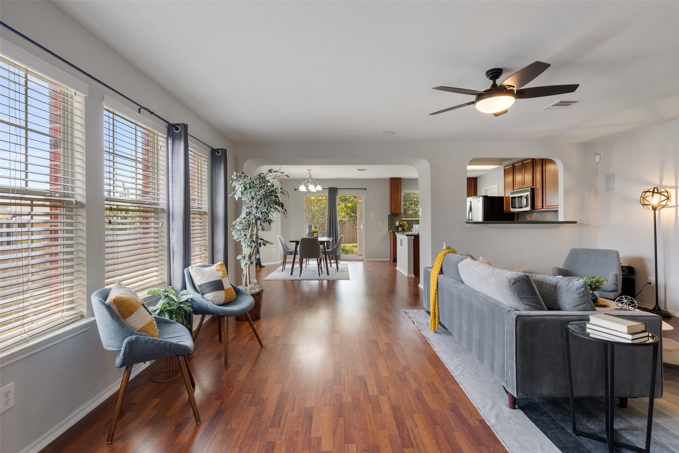 517 Castebar Drive Round Rock, TX 78664 - Photo 10 of 37 Living area featuring wood finished floors, ceiling fan, a chandelier, arched walkways, and baseboards
