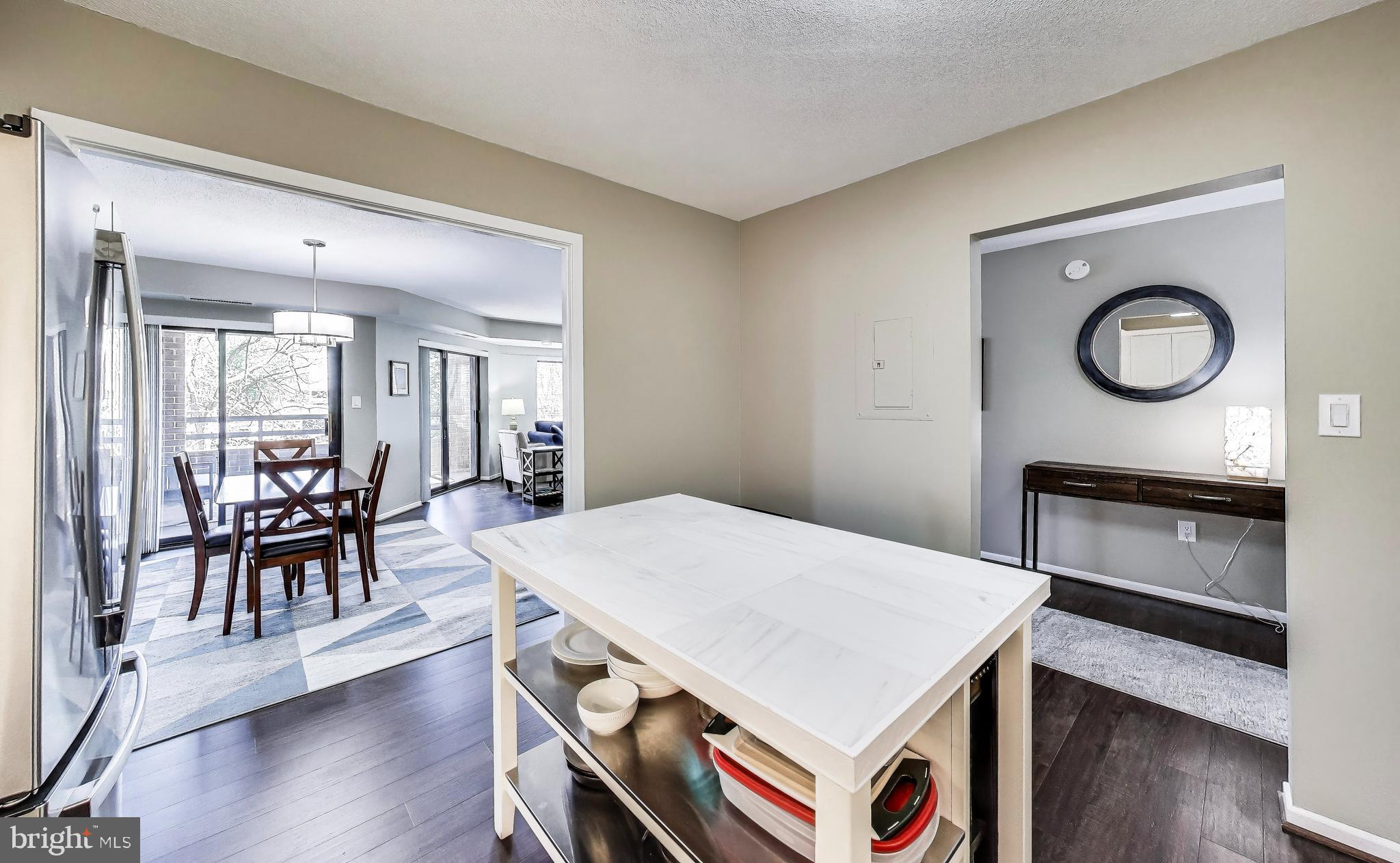 2111 Wisconsin Avenue Northwest, Unit 109 Washington, DC 20007 - Photo 17 of 50 a open kitchen with a dining table and chairs