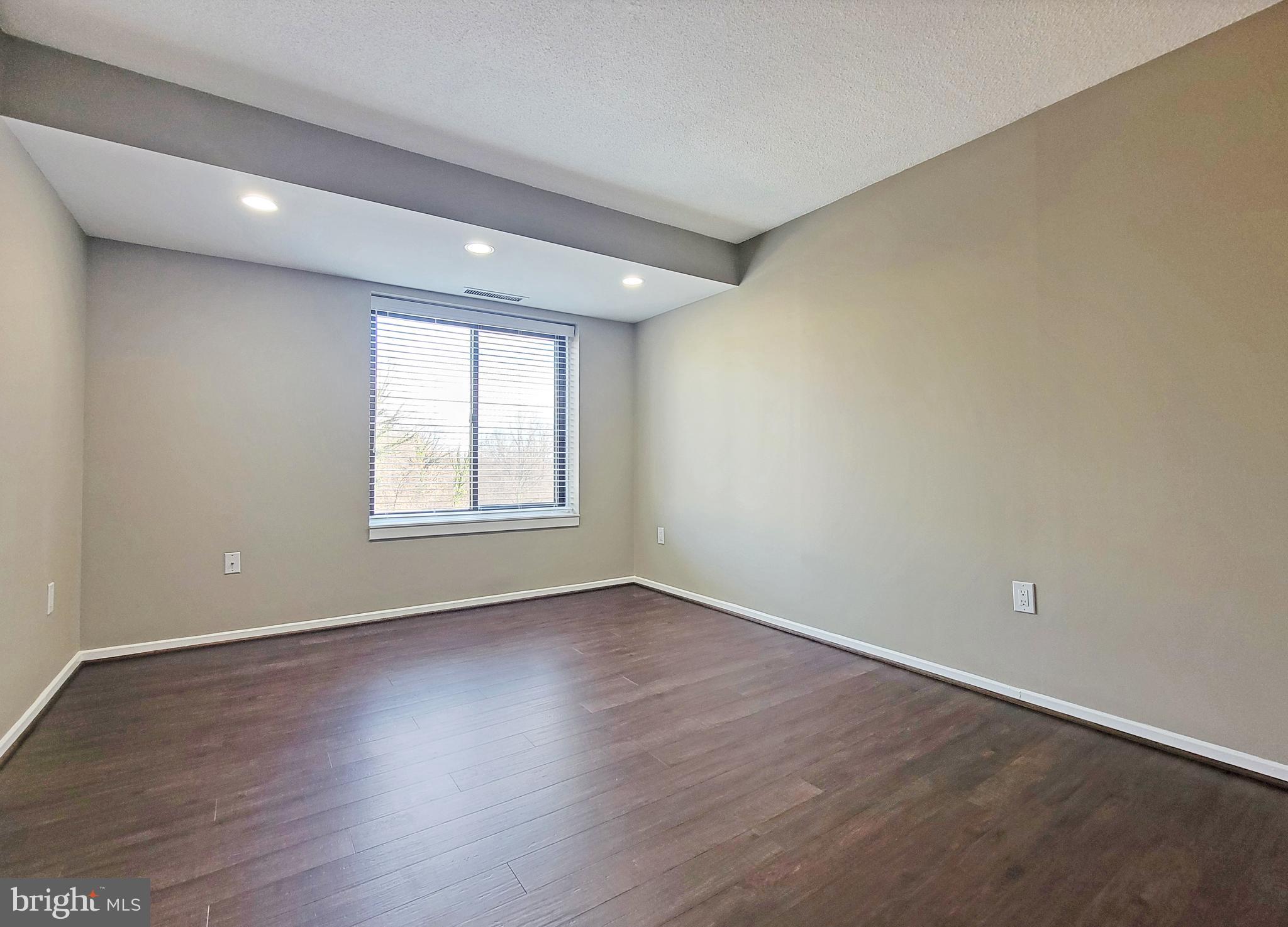 2111 Wisconsin Avenue Northwest, Unit 109 Washington, DC 20007 - Photo 30 of 50 wooden floor in an empty room with a window