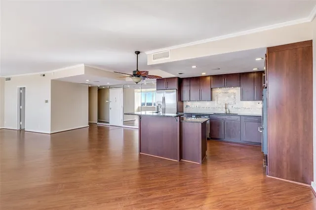 a kitchen with stainless steel appliances granite countertop a sink cabinets and wooden floor