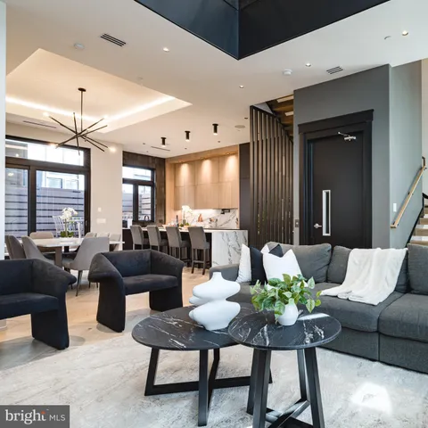 a living room with furniture kitchen view and a large window