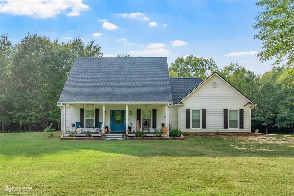 3734 Dorcheat Road Minden, LA 71055 - Photo 1 of 1 View of front of home featuring a porch, a shingled roof, and a front lawn
