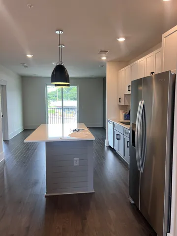 a kitchen with stainless steel appliances a refrigerator a stove a microwave and a hard wood floor