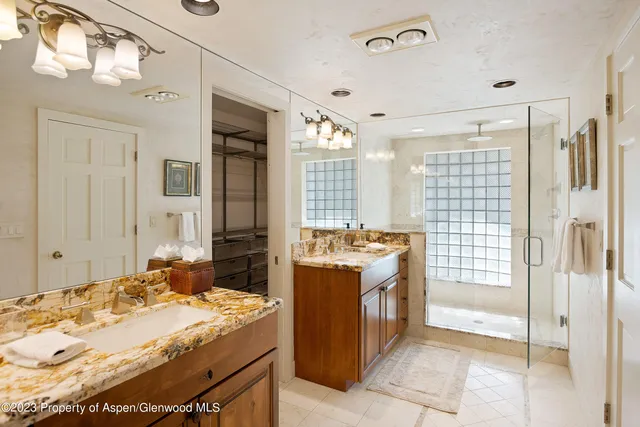 a room with a dresser and chandelier