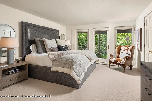 a large bed sitting in a bedroom next to a window