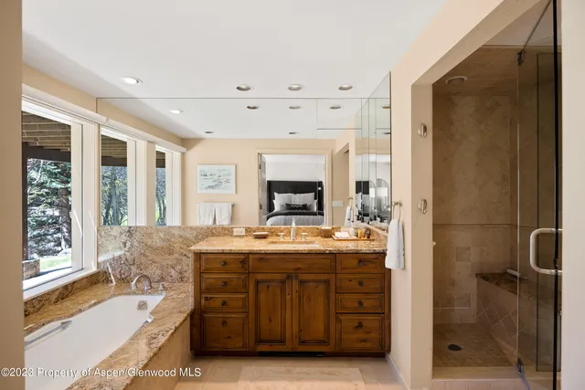 a en suite bathroom with a granite countertop sink mirror and shower