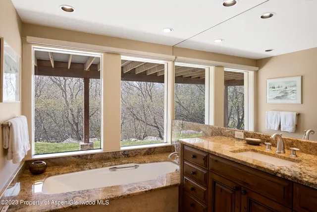 a bathroom with a granite countertop sink and a large mirror