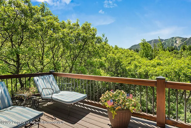 a view of a balcony with wooden floor and outdoor seating