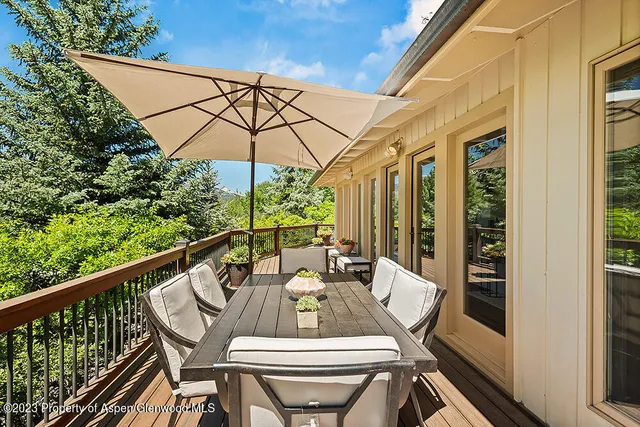 a view of balcony with furniture and umbrella