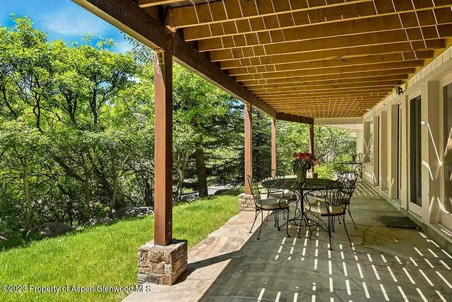 a view of a patio with table and chairs and wooden floor