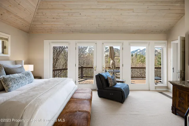 a spacious bedroom with a bed and glass door