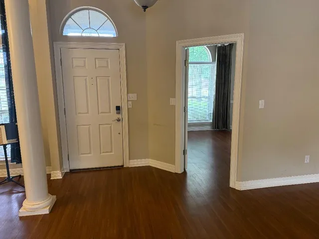 an empty room with wooden floor and a window