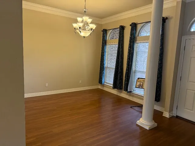 a view of a livingroom with wooden floor and staircase