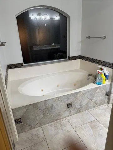 a bathroom with a large tub and shower