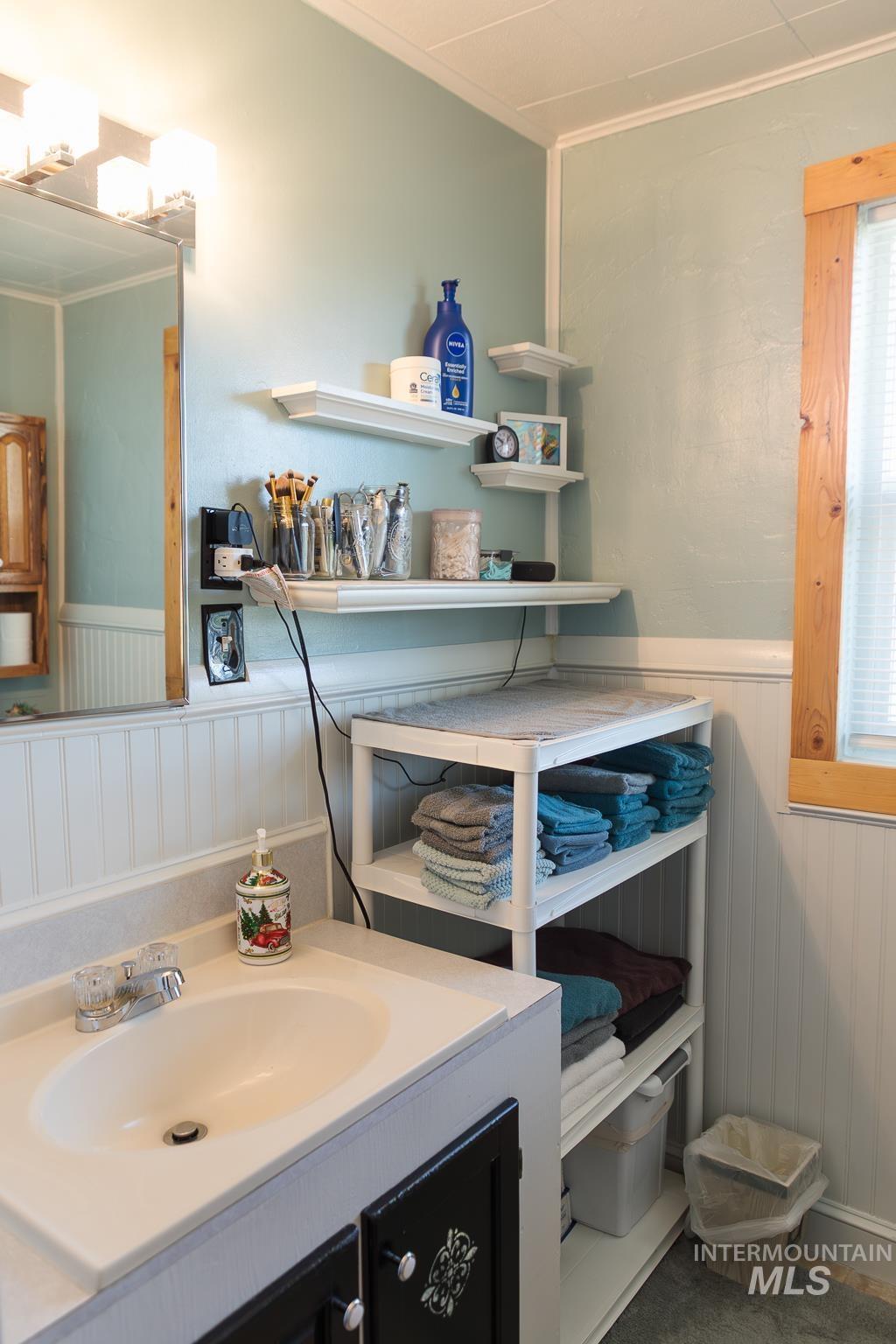 211 Northeast 3rd Avenue Ontario, OR 97914 - Photo 21 of 40 Bathroom featuring wainscoting, vanity, ornamental molding, and wood walls