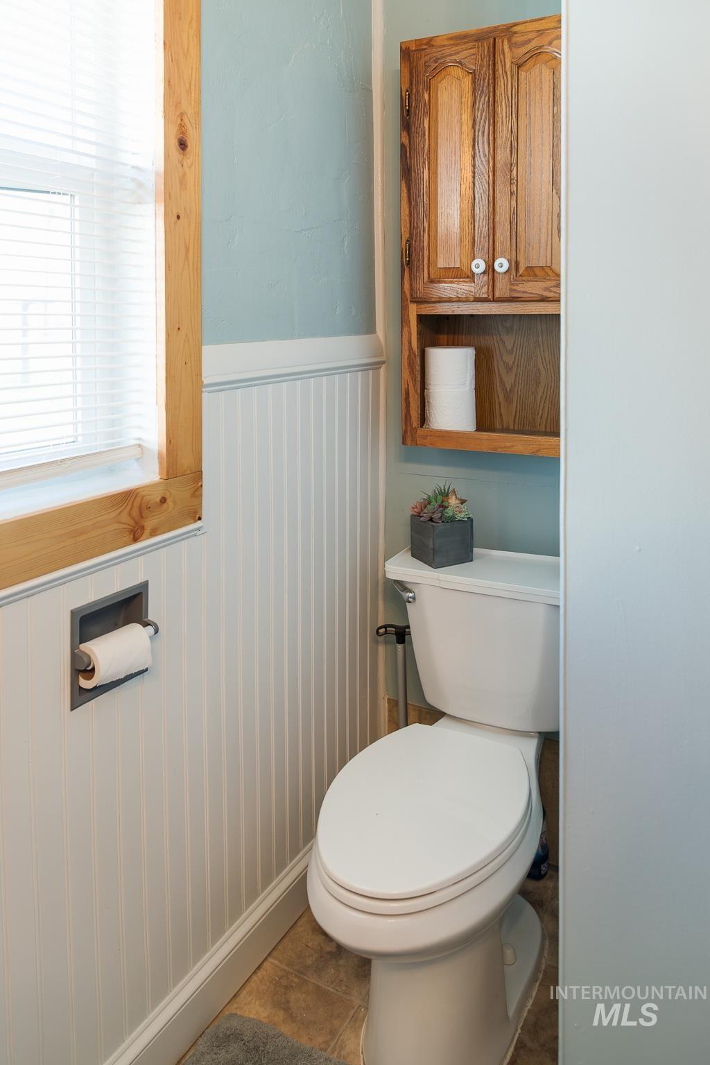 211 Northeast 3rd Avenue Ontario, OR 97914 - Photo 22 of 40 Bathroom featuring a wainscoted wall and dark tile patterned floors