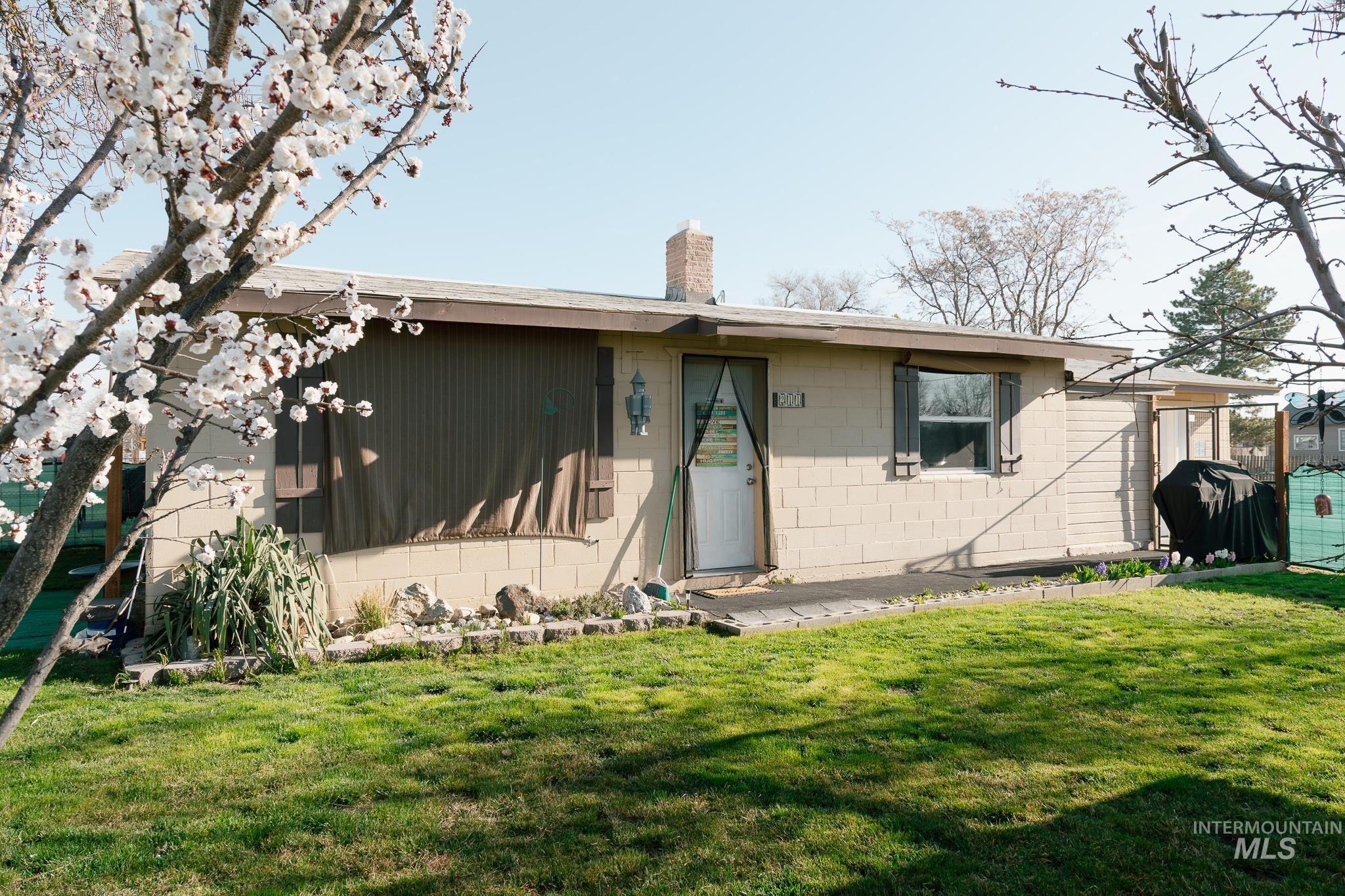211 Northeast 3rd Avenue Ontario, OR 97914 - Photo 34 of 40 View of front of home with concrete block siding, a front lawn, and a chimney