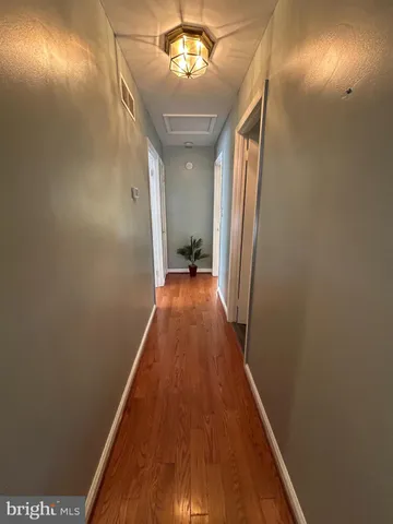 a bedroom with a bed table flowerpot and a window