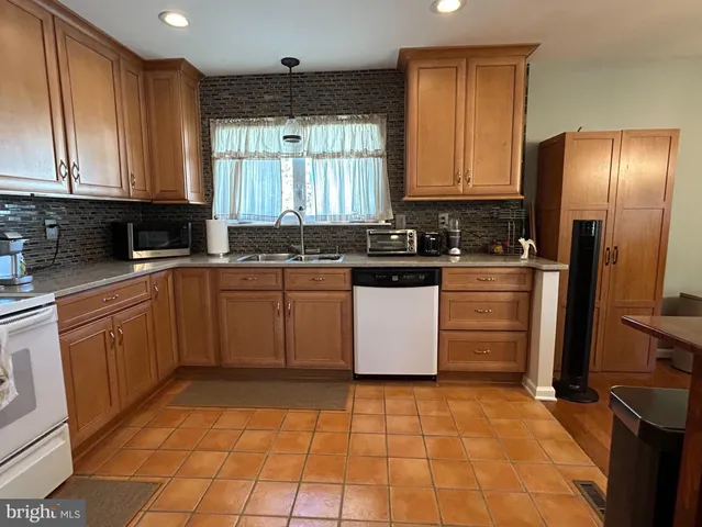a kitchen with a sink a refrigerator and cabinets