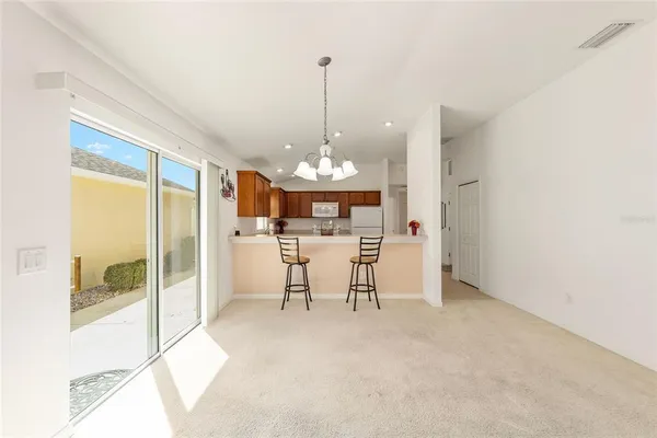 a view of a dining room with furniture a chandelier and a rug