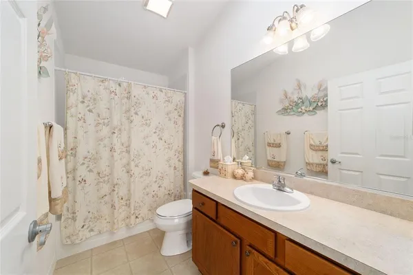 a bathroom with a granite countertop sink a toilet and a shower