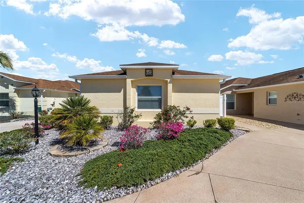 a front view of a house with a garden