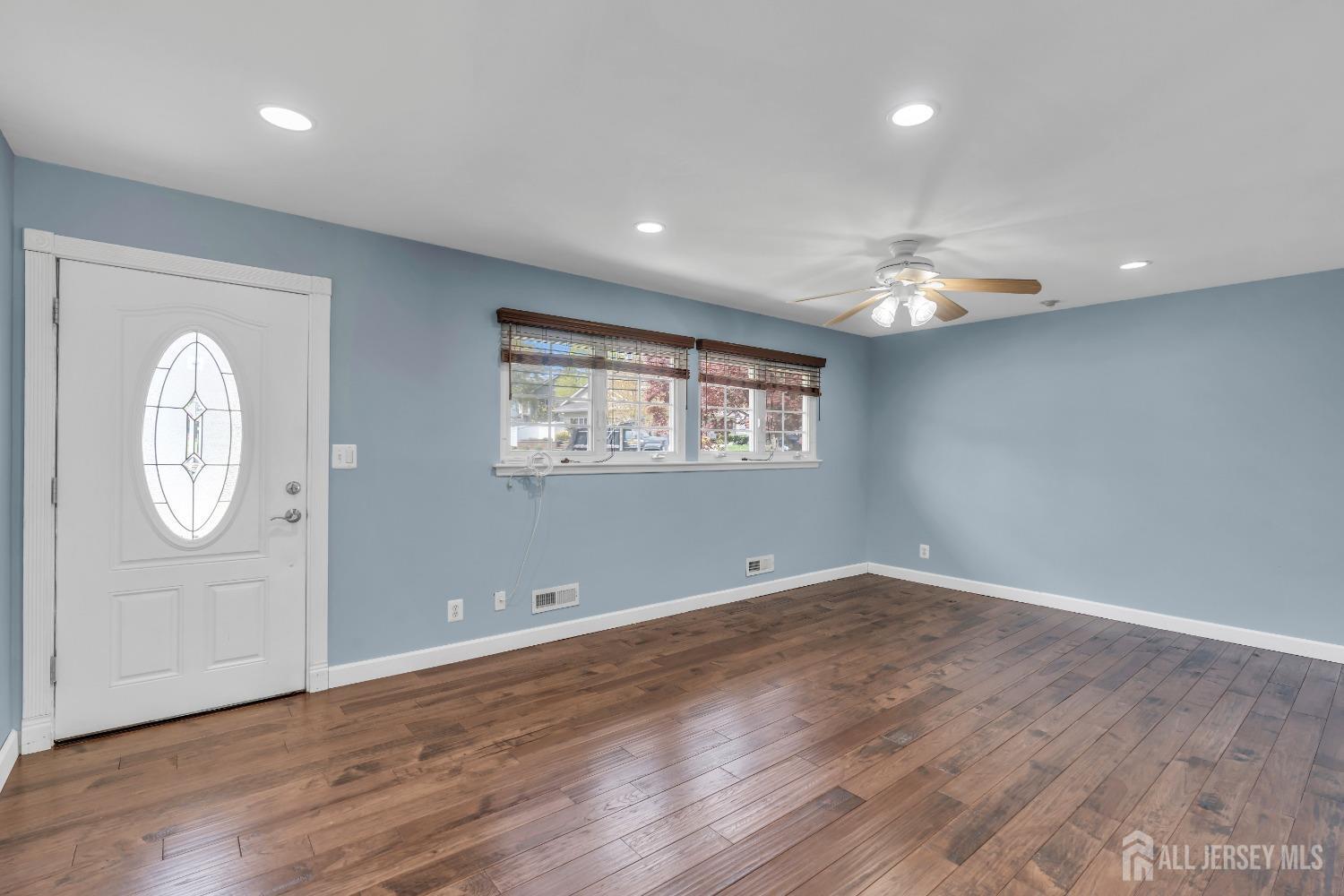 27 Brookside Road Edison, NJ 08817 - Photo 4 of 35 an empty room with wooden floor mirror and windows