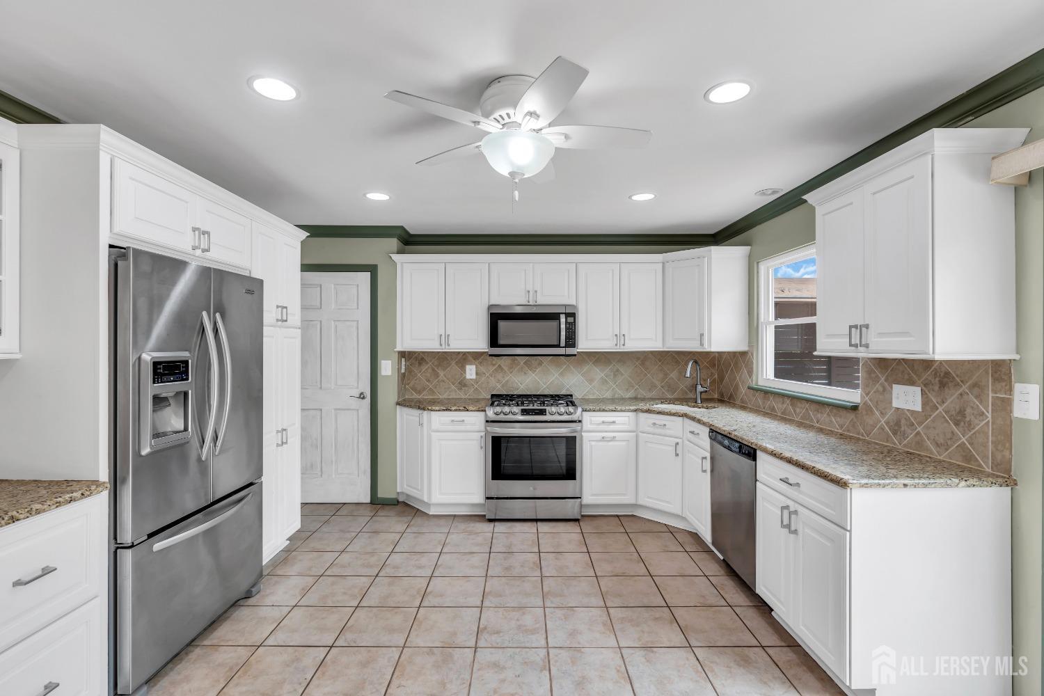 27 Brookside Road Edison, NJ 08817 - Photo 7 of 35 a large kitchen with stainless steel appliances granite countertop a stove top oven a sink and a refrigerator