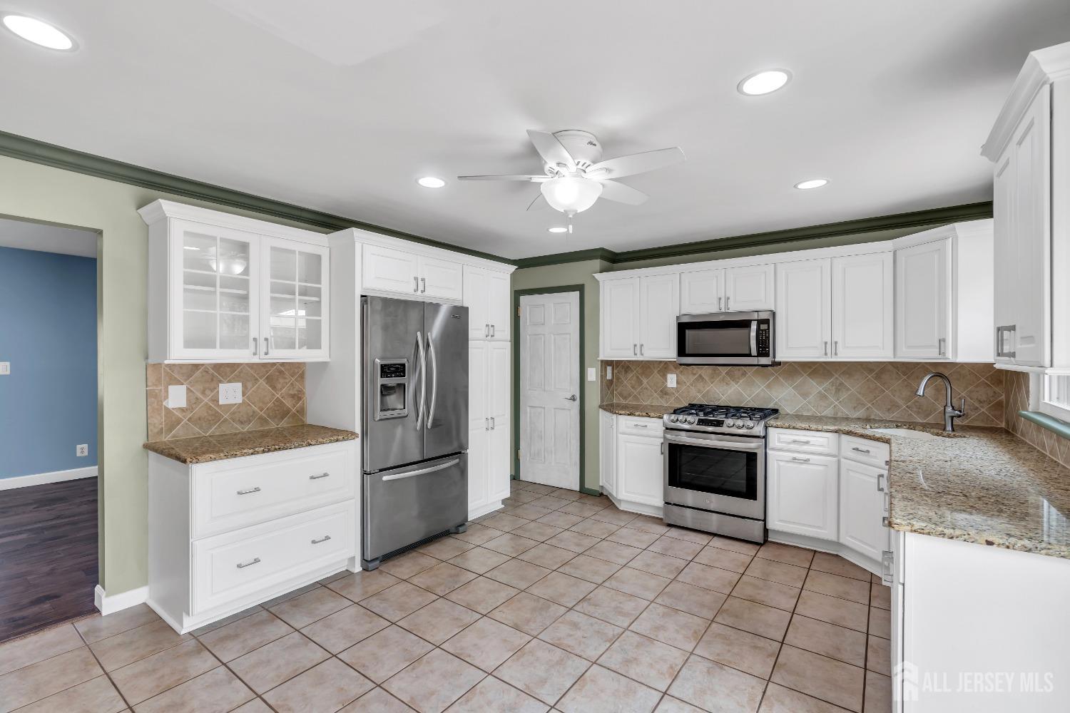 27 Brookside Road Edison, NJ 08817 - Photo 9 of 35 a kitchen with stainless steel appliances granite countertop a refrigerator and a stove top oven