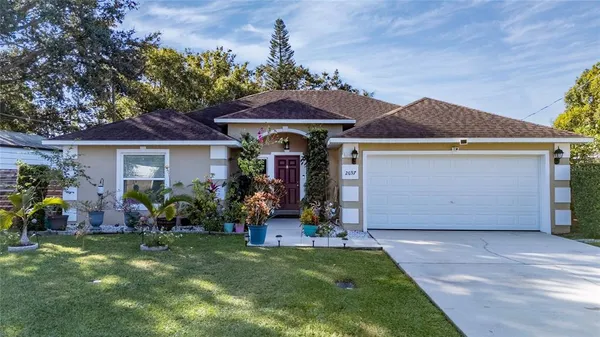 a front view of a house with a garden and plants