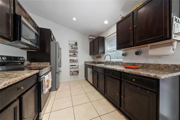 a kitchen with stainless steel appliances granite countertop a stove a sink and a microwave