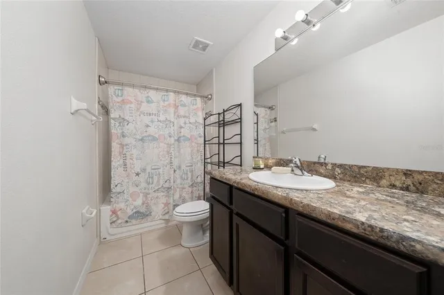 a spacious bedroom with a bed and a cabinets