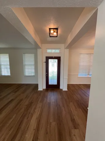 a view of a room with wooden floor and a window