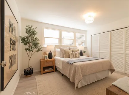 a bedroom with a bed and a potted plant
