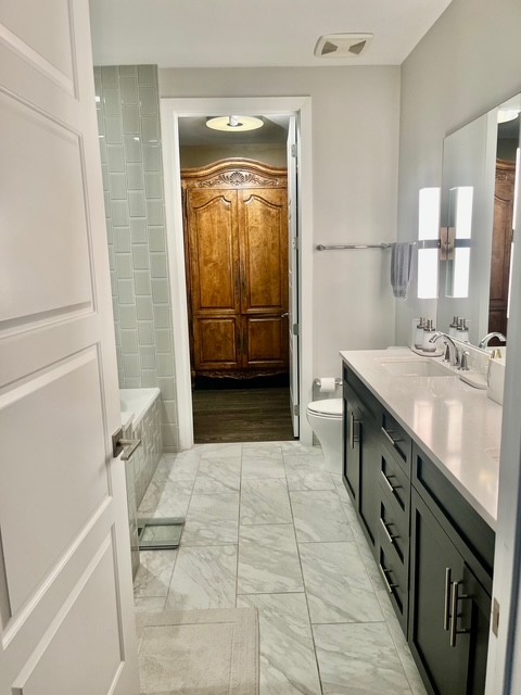 20 Rutledge Street, Unit 108 Nashville, TN 37210 - Photo 18 of 56 a bathroom with a double vanity sink a toilet and a mirror