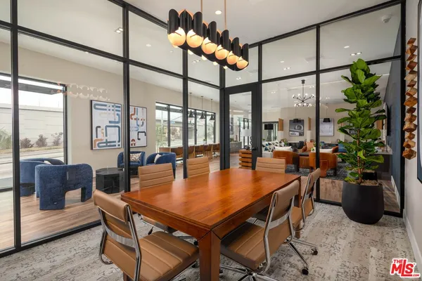 a dining room with furniture a floor to ceiling window and potted plants