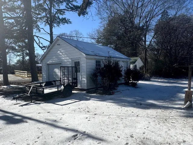 a view of a house with snow on the side of the road