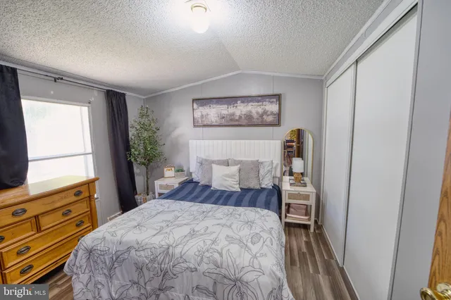 a bedroom with a bed and a dresser next to a window