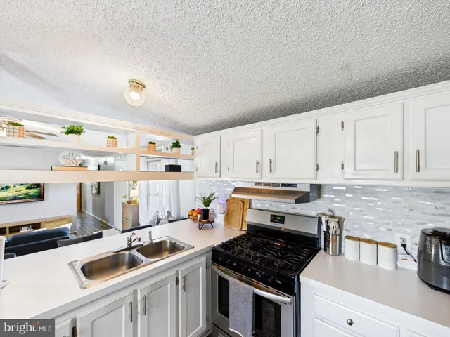 a kitchen with stainless steel appliances granite countertop a sink stove and cabinets