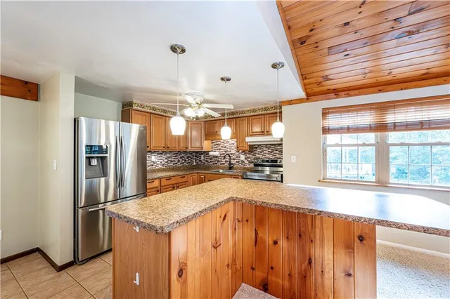 a kitchen with stainless steel appliances granite countertop a refrigerator and a sink