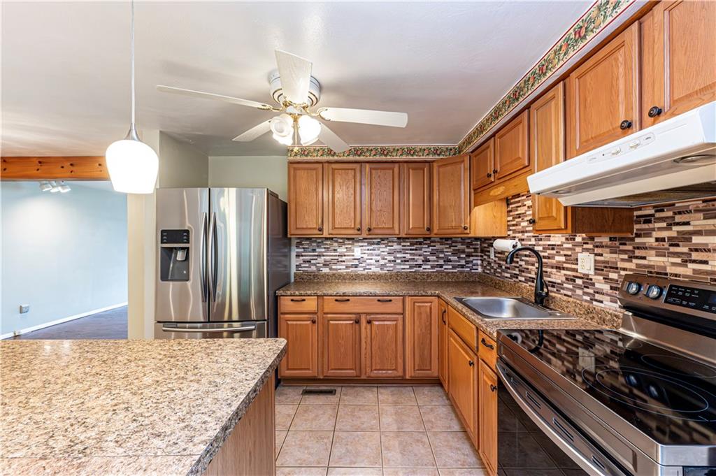 11320 James Street Irwin, PA 15642 - Photo 6 of 42 a kitchen with stainless steel appliances granite countertop a stove a sink and a refrigerator