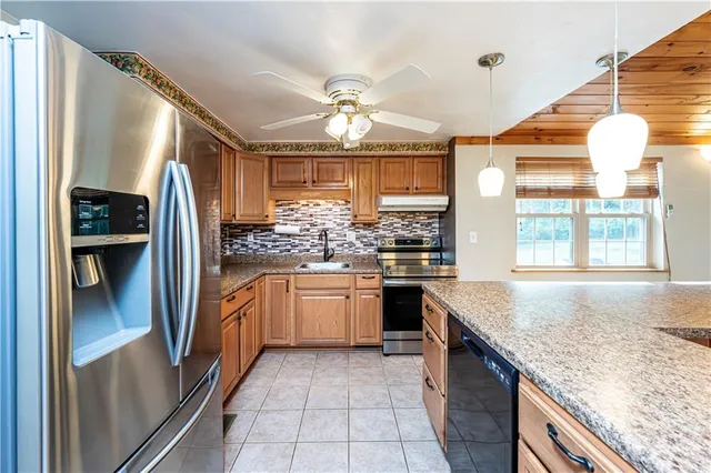 a kitchen with stainless steel appliances granite countertop a refrigerator and a sink