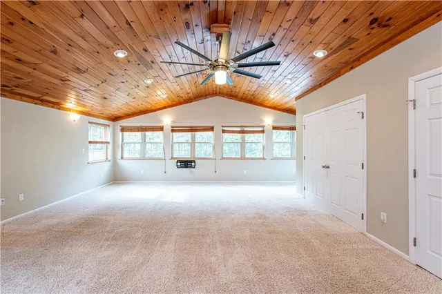 a big room with chandelier fan and windows