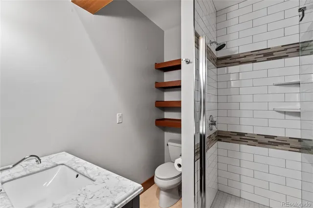 a bathroom with a sink a toilet and shower